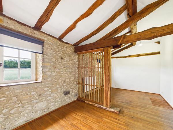 Belle maison de maître en pierre située dans un paysage vallonné en pleine campagne