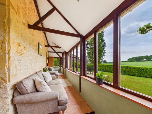 Belle maison de maître en pierre située dans un paysage vallonné en pleine campagne