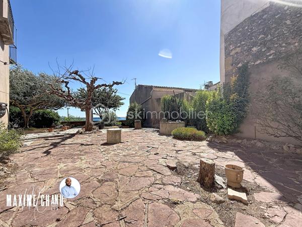 Perchée à Bouzigues, cette maison vigneronne de caractère d'environ 165 m² habitables vous offre l'une des plus belles vues du village : un panorama imprenable à 180° sur le Bassin de Thau, où le temps semble suspendre son cours face à l'horizon.

Dès l'entrée, un vaste espace d'environ 120 m² au rez-de-chaussée, aujourd'hui dédié au garage et au rangement, offre un potentiel remarquable pour organiser vos volumes selon vos envies et vos projets. Ce niveau donne un accès direct au jardin et à sa vue imprenable, prolongeant naturellement la projection futur vers l'extérieur.

À l'étage, la maison prend tout son sens : un séjour et une cuisine, quatre chambres confortables, ainsi que plusieurs espaces extérieurs où le regard porte sans obstacle jusqu'au Bassin. Un cadre rare, pensé pour profiter pleinement du site.

Le dernier niveau propose une pièce supplémentaire ainsi que des combles, totalisant environ 66 m², une belle réserve de possibilités pour agrandir les espaces de vie ou aménager selon vos besoins.

Cette maison nécessite des travaux de rénovation, mais son cadre exceptionnel, son fort caractère architectural et son jardin calme où l'on aime s'arrêter pour contempler l'horizon séduiront les amateurs de biens atypiques prêts à se laisser porter par le charme du lieu. Vue imprenable sur le Bassin de Thau, fort potentiel de rénovation, calme absolu et authenticité d'une véritable maison vigneronne : cette propriété réunit tous les ingrédients d'une opportunité rare, parmi les plus belles vues de Bouzigues.

À découvrir sans tarder !