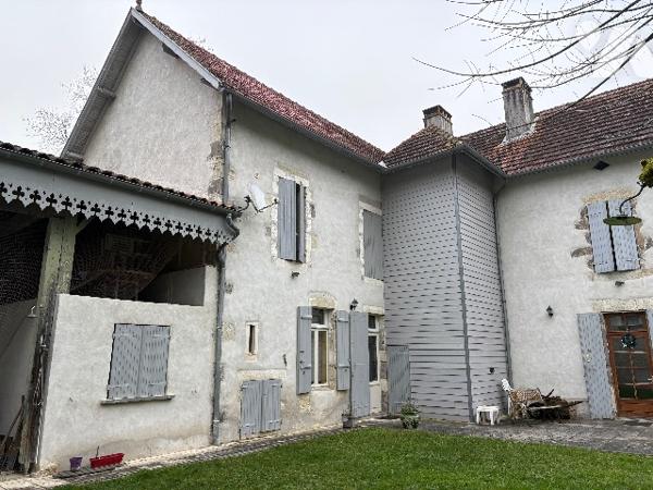 Très bel ensemble en pierre de 1860, sur un parc boisé de plus d'1,8 HA, en sortie de ville.