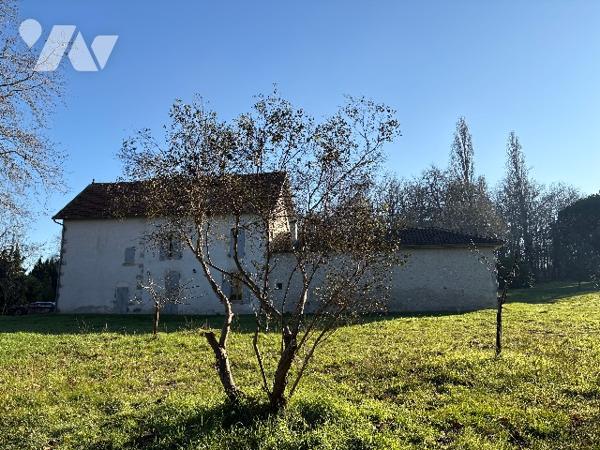 Très bel ensemble en pierre de 1860, sur un parc boisé de plus d'1,8 HA, en sortie de ville.
