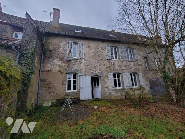 Ensemble immobilier situé dans le bourg d'AHUN, construit en pierres et couvert en petites tuil...