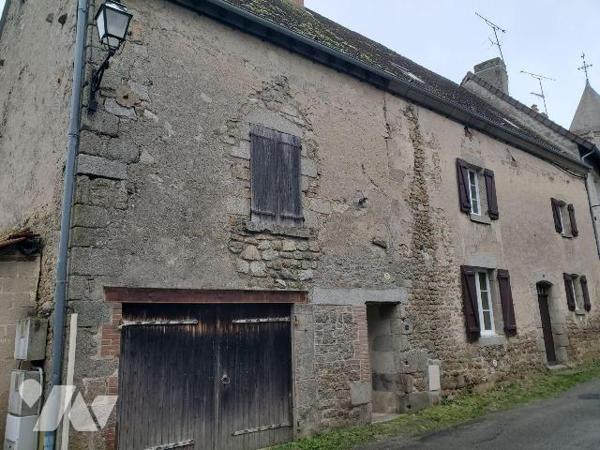 Ensemble immobilier situé dans le bourg d'AHUN, construit en pierres et couvert en petites tuil...