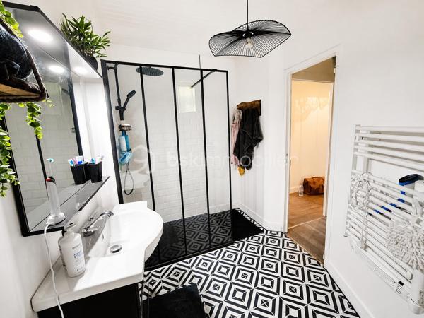 Dès l’entrée, vous découvrirez une agréable pièce de vie d’environ 27,5 m², composée d’une cuisine équipée et aménagée ouverte sur un espace salon/salle à manger. La cuisine aménagée dispose d’une plaque gaz, d’un four électrique, d’un lave-vaisselle et d’une hotte aspirante.
Le rez-de-chaussée comprend également un cellier/buanderie d’environ 10 m², avec les raccordements nécessaires pour un lave-linge et un sèche-linge, ainsi qu’un WC d’environ 1,5 m².

À l’étage : 
Un palier d’environ 3 m² dessert :
•	Une chambre d’environ 11 m²
•	Une chambre d’environ 14 m², avec placard intégré
•	Un bureau d’environ 4,5 m², bénéficiant d’un accès direct au jardin
•	Une salle d’eau d’environ 5 m², équipée d’une douche à l’italienne, d’un meuble sous vasque, d’un WC et d’un sèche-serviettes électrique soufflant

Les combles :  Accessibles à partir d’un bel escalier, ne sont pas aménagés mais permettent un vaste stockage.

Le Jardin : 
À l’arrière, vous profiterez d’un petit jardin entièrement clôturé et préservé des regards grâce aux palissades et aux végétaux.
Vous disposerez également d’une terrasse en lames composites, d’une partie gazonnée et d’une Pergola. La terrasse bénéficie d’un point lumineux et d’une prise électrique.

Technique : 
•	Pompe à chaleur air/air (2018)
•	Combles isolés (2022)
•	Double vitrage PVC, à l’exception de la porte donnant sur le jardin
•	Toiture récente (2020)
•	Salle d’eau refaite intégralement (2022)
•	Extracteur d’air dans la salle d’eau
•	Volets bois récemment repeints
•      Assainissement collectif