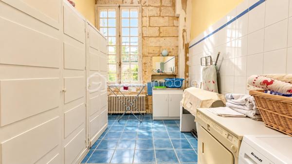 À proximité immédiate du centre-ville de Bergerac, découvrez cette demeure ancienne de caractère d’environ 243 m² habitables mitoyenne , implantée sur une parcelle d’environ 624 m².

Dès l’entrée, le charme de l’ancien est au rendez-vous : belles hauteurs sous plafond, carreaux anciens, cheminées, grandes ouvertures et volumes généreux créent une atmosphère chaleureuse et authentique.

Au rez-de-chaussée, la maison offre un séjour d’environ 30 m², un salon d’environ 22 m², une cuisine indépendante aménagée et équipée d’environ 22 m², une chambre de plus de 14 m², une salle de bains avec baignoire et douche ainsi qu’une buanderie.

Depuis la cuisine, un accès mène directement à une grande cave d’environ 63 m² située sous la maison. Un espace particulièrement appréciable, offrant une importante capacité de stockage et tout le charme que l’on attend d’une demeure ancienne.

À l’étage, l’espace nuit se compose de quatre chambres supplémentaires, d’environ 12 à 19 m², ainsi que d’une remarquable salle de jeux d’environ 30 m². Un véritable espace supplémentaire qui pourra devenir, selon les envies, salon familial, salle de cinéma, bureau, atelier ou espace dédié aux enfants. Une seconde salle d’eau complète ce niveau.

À l’extérieur, le jardin clos constitue un véritable privilège à proximité du cœur de Bergerac.

La propriété dispose également d’un garage d’environ 37 m² avec porte motorisée, surmonté d’un étage d’environ 37 m² offrant encore de belles possibilités, ainsi que d’un ancien pigeonnier indépendant qui participe pleinement au caractère des lieux.

La maison est raccordée au tout-à-l’égout et bénéficie d’un chauffage au gaz de ville au rez-de-chaussée, complété par des radiateurs électriques à l’étage. Son DPE classé C représente un véritable atout pour une demeure ancienne de cette superficie.

Quelques travaux de rafraîchissement permettront de révéler tout son potentiel et de la personnaliser sans lui retirer son identité.

243 m² habitables, 5 chambres, environ 624 m² de terrain, une cave de 63 m² sous la maison, un garage avec étage et un pigeonnier : une propriété aux volumes rares, destinée aux amoureux des maisons de caractère.

Une demeure qui se visite autant avec les yeux qu’avec le cœur.