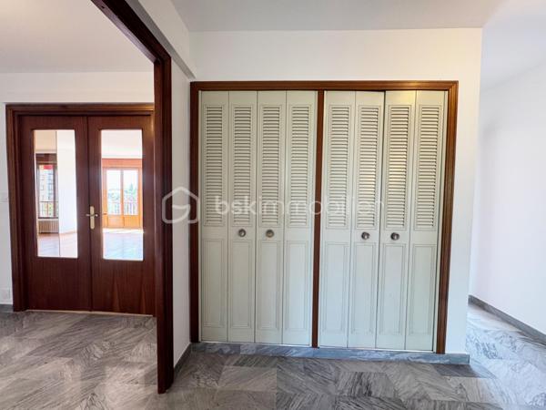 Au sein de la copropriété de standing Le Saint André à ÉCHIROLLES, cet appartement de 107,69 m² occupe le 4ᵉ étage sur 7. Traversant est / ouest, il offre une double orientation et des vues dégagées sur les massifs, du lever au coucher du soleil.

Une vaste entrée de 10,30 m² dessert un remarquable espace de vie de près de 36 m², organisé en double séjour avec sa salle à manger. Ouvert sur un balcon de 8,50 m², il domine le grand parc arboré de la copropriété, avec la chaîne de Belledonne en toile de fond : une vue dégagée et apaisante, sans aucun vis-à-vis. La cuisine, indépendante et de belles dimensions (près de 11 m²), se prolonge quant à elle par une loggia côté Vercors.

L'espace nuit se compose de trois chambres, toutes dotées d'une vue : deux ouvrent sur le massif du Vercors, la troisième sur le parc et la chaîne de Belledonne. La chambre principale est équipée son coin d'eau privatif et de son dressing. Une salle d'eau récente, un WC séparé, un second dressing et un dégagement de 7,60 m² entièrement équipé de placards complètent une distribution particulièrement fonctionnelle : les rangements ne manquent pas.

L'appartement a fait l'objet d'une rénovation complète : électricité entièrement refaite à neuf, peintures reprises dans l'ensemble des pièces, double vitrage récent de haute qualité, salle d'eau récente et climatisation dans la pièce de vie comme dans les chambres. Un logement prêt à vivre, sans aucun travaux à prévoir.

Une cave en sous-sol complète le bien. 
Deux places de parking sont par ailleurs proposées en sus, au prix de 7 000 € chacune.
