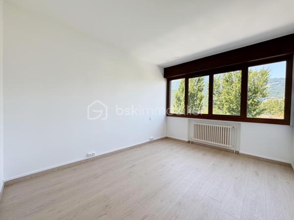 Au sein de la copropriété de standing Le Saint André à ÉCHIROLLES, cet appartement de 107,69 m² occupe le 4ᵉ étage sur 7. Traversant est / ouest, il offre une double orientation et des vues dégagées sur les massifs, du lever au coucher du soleil.

Une vaste entrée de 10,30 m² dessert un remarquable espace de vie de près de 36 m², organisé en double séjour avec sa salle à manger. Ouvert sur un balcon de 8,50 m², il domine le grand parc arboré de la copropriété, avec la chaîne de Belledonne en toile de fond : une vue dégagée et apaisante, sans aucun vis-à-vis. La cuisine, indépendante et de belles dimensions (près de 11 m²), se prolonge quant à elle par une loggia côté Vercors.

L'espace nuit se compose de trois chambres, toutes dotées d'une vue : deux ouvrent sur le massif du Vercors, la troisième sur le parc et la chaîne de Belledonne. La chambre principale est équipée son coin d'eau privatif et de son dressing. Une salle d'eau récente, un WC séparé, un second dressing et un dégagement de 7,60 m² entièrement équipé de placards complètent une distribution particulièrement fonctionnelle : les rangements ne manquent pas.

L'appartement a fait l'objet d'une rénovation complète : électricité entièrement refaite à neuf, peintures reprises dans l'ensemble des pièces, double vitrage récent de haute qualité, salle d'eau récente et climatisation dans la pièce de vie comme dans les chambres. Un logement prêt à vivre, sans aucun travaux à prévoir.

Une cave en sous-sol complète le bien. 
Deux places de parking sont par ailleurs proposées en sus, au prix de 7 000 € chacune.