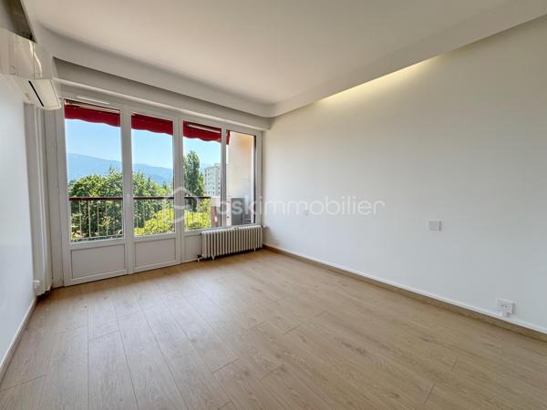 Au sein de la copropriété de standing Le Saint André à ÉCHIROLLES, cet appartement de 107,69 m² occupe le 4ᵉ étage sur 7. Traversant est / ouest, il offre une double orientation et des vues dégagées sur les massifs, du lever au coucher du soleil.

Une vaste entrée de 10,30 m² dessert un remarquable espace de vie de près de 36 m², organisé en double séjour avec sa salle à manger. Ouvert sur un balcon de 8,50 m², il domine le grand parc arboré de la copropriété, avec la chaîne de Belledonne en toile de fond : une vue dégagée et apaisante, sans aucun vis-à-vis. La cuisine, indépendante et de belles dimensions (près de 11 m²), se prolonge quant à elle par une loggia côté Vercors.

L'espace nuit se compose de trois chambres, toutes dotées d'une vue : deux ouvrent sur le massif du Vercors, la troisième sur le parc et la chaîne de Belledonne. La chambre principale est équipée son coin d'eau privatif et de son dressing. Une salle d'eau récente, un WC séparé, un second dressing et un dégagement de 7,60 m² entièrement équipé de placards complètent une distribution particulièrement fonctionnelle : les rangements ne manquent pas.

L'appartement a fait l'objet d'une rénovation complète : électricité entièrement refaite à neuf, peintures reprises dans l'ensemble des pièces, double vitrage récent de haute qualité, salle d'eau récente et climatisation dans la pièce de vie comme dans les chambres. Un logement prêt à vivre, sans aucun travaux à prévoir.

Une cave en sous-sol complète le bien. 
Deux places de parking sont par ailleurs proposées en sus, au prix de 7 000 € chacune.