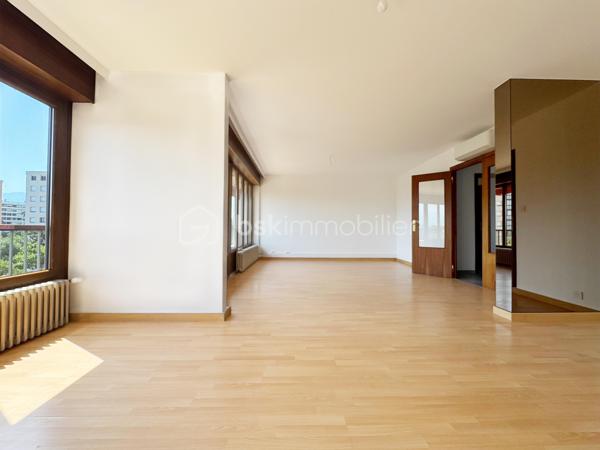 Au sein de la copropriété de standing Le Saint André à ÉCHIROLLES, cet appartement de 107,69 m² occupe le 4ᵉ étage sur 7. Traversant est / ouest, il offre une double orientation et des vues dégagées sur les massifs, du lever au coucher du soleil.

Une vaste entrée de 10,30 m² dessert un remarquable espace de vie de près de 36 m², organisé en double séjour avec sa salle à manger. Ouvert sur un balcon de 8,50 m², il domine le grand parc arboré de la copropriété, avec la chaîne de Belledonne en toile de fond : une vue dégagée et apaisante, sans aucun vis-à-vis. La cuisine, indépendante et de belles dimensions (près de 11 m²), se prolonge quant à elle par une loggia côté Vercors.

L'espace nuit se compose de trois chambres, toutes dotées d'une vue : deux ouvrent sur le massif du Vercors, la troisième sur le parc et la chaîne de Belledonne. La chambre principale est équipée son coin d'eau privatif et de son dressing. Une salle d'eau récente, un WC séparé, un second dressing et un dégagement de 7,60 m² entièrement équipé de placards complètent une distribution particulièrement fonctionnelle : les rangements ne manquent pas.

L'appartement a fait l'objet d'une rénovation complète : électricité entièrement refaite à neuf, peintures reprises dans l'ensemble des pièces, double vitrage récent de haute qualité, salle d'eau récente et climatisation dans la pièce de vie comme dans les chambres. Un logement prêt à vivre, sans aucun travaux à prévoir.

Une cave en sous-sol complète le bien. 
Deux places de parking sont par ailleurs proposées en sus, au prix de 7 000 € chacune.