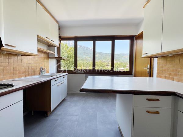 Au sein de la copropriété de standing Le Saint André à ÉCHIROLLES, cet appartement de 107,69 m² occupe le 4ᵉ étage sur 7. Traversant est / ouest, il offre une double orientation et des vues dégagées sur les massifs, du lever au coucher du soleil.

Une vaste entrée de 10,30 m² dessert un remarquable espace de vie de près de 36 m², organisé en double séjour avec sa salle à manger. Ouvert sur un balcon de 8,50 m², il domine le grand parc arboré de la copropriété, avec la chaîne de Belledonne en toile de fond : une vue dégagée et apaisante, sans aucun vis-à-vis. La cuisine, indépendante et de belles dimensions (près de 11 m²), se prolonge quant à elle par une loggia côté Vercors.

L'espace nuit se compose de trois chambres, toutes dotées d'une vue : deux ouvrent sur le massif du Vercors, la troisième sur le parc et la chaîne de Belledonne. La chambre principale est équipée son coin d'eau privatif et de son dressing. Une salle d'eau récente, un WC séparé, un second dressing et un dégagement de 7,60 m² entièrement équipé de placards complètent une distribution particulièrement fonctionnelle : les rangements ne manquent pas.

L'appartement a fait l'objet d'une rénovation complète : électricité entièrement refaite à neuf, peintures reprises dans l'ensemble des pièces, double vitrage récent de haute qualité, salle d'eau récente et climatisation dans la pièce de vie comme dans les chambres. Un logement prêt à vivre, sans aucun travaux à prévoir.

Une cave en sous-sol complète le bien. 
Deux places de parking sont par ailleurs proposées en sus, au prix de 7 000 € chacune.