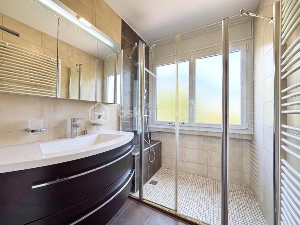 Au sein de la copropriété de standing Le Saint André à ÉCHIROLLES, cet appartement de 107,69 m² occupe le 4ᵉ étage sur 7. Traversant est / ouest, il offre une double orientation et des vues dégagées sur les massifs, du lever au coucher du soleil.

Une vaste entrée de 10,30 m² dessert un remarquable espace de vie de près de 36 m², organisé en double séjour avec sa salle à manger. Ouvert sur un balcon de 8,50 m², il domine le grand parc arboré de la copropriété, avec la chaîne de Belledonne en toile de fond : une vue dégagée et apaisante, sans aucun vis-à-vis. La cuisine, indépendante et de belles dimensions (près de 11 m²), se prolonge quant à elle par une loggia côté Vercors.

L'espace nuit se compose de trois chambres, toutes dotées d'une vue : deux ouvrent sur le massif du Vercors, la troisième sur le parc et la chaîne de Belledonne. La chambre principale est équipée son coin d'eau privatif et de son dressing. Une salle d'eau récente, un WC séparé, un second dressing et un dégagement de 7,60 m² entièrement équipé de placards complètent une distribution particulièrement fonctionnelle : les rangements ne manquent pas.

L'appartement a fait l'objet d'une rénovation complète : électricité entièrement refaite à neuf, peintures reprises dans l'ensemble des pièces, double vitrage récent de haute qualité, salle d'eau récente et climatisation dans la pièce de vie comme dans les chambres. Un logement prêt à vivre, sans aucun travaux à prévoir.

Une cave en sous-sol complète le bien. 
Deux places de parking sont par ailleurs proposées en sus, au prix de 7 000 € chacune.