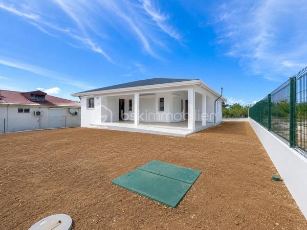 Située à Baie-Mahault, dans un environnement résidentiel au calme, je vous propose cette superbe villa neuve de plain-pied de 105 m² (surface utile 144,65 m2), édifiée sur une parcelle de 586 m² sécurisée par un portail motorisé.
À l’avant de la maison une grande terrasse de 39 m2, attenante à un WC visiteur indépendant.
Un séjour de 32 m2 environ offre une belle pièce de vie, lumineuse ouverte sur la terrasse.
La cuisine aménagée avec une vue sur le jardin, avec un beau cellier pour le rangement de vos provisions.
Concernant la partie nuit, un dégagement dessert une salle d’eau/WC, trois chambres, dont une belle suite parentale de 18,53 m2 avec sa salle d’eau/WC, ainsi qu’une buanderie indépendante.
Vous l’aurez compris, cette maison NEUVE est prête à accueillir votre famille. Elle vous séduira par ses volumes, sa luminosité et son emplacement dans ce secteur apprécié pour :
- son environnement résidentiel calme ;
- sa proximité avec le centre de Baie-Mahault ;
- son accès rapide à Jarry, Destreland, aux écoles et aux principaux axes routiers

Les maisons neuves disponibles immédiatement sont peu nombreuses sur le marché. Si vous recherchez un bien confortable, moderne et prêt à accueillir votre famille, ne tardez pas à programmer votre visite.
📞 Contactez-moi dès aujourd'hui. Une visite pourrait être le début de votre nouveau projet de vie.