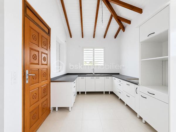 Située à Baie-Mahault, dans un environnement résidentiel au calme, je vous propose cette superbe villa neuve de plain-pied de 105 m² (surface utile 144,65 m2), édifiée sur une parcelle de 586 m² sécurisée par un portail motorisé.
À l’avant de la maison une grande terrasse de 39 m2, attenante à un WC visiteur indépendant.
Un séjour de 32 m2 environ offre une belle pièce de vie, lumineuse ouverte sur la terrasse.
La cuisine aménagée avec une vue sur le jardin, avec un beau cellier pour le rangement de vos provisions.
Concernant la partie nuit, un dégagement dessert une salle d’eau/WC, trois chambres, dont une belle suite parentale de 18,53 m2 avec sa salle d’eau/WC, ainsi qu’une buanderie indépendante.
Vous l’aurez compris, cette maison NEUVE est prête à accueillir votre famille. Elle vous séduira par ses volumes, sa luminosité et son emplacement dans ce secteur apprécié pour :
- son environnement résidentiel calme ;
- sa proximité avec le centre de Baie-Mahault ;
- son accès rapide à Jarry, Destreland, aux écoles et aux principaux axes routiers

Les maisons neuves disponibles immédiatement sont peu nombreuses sur le marché. Si vous recherchez un bien confortable, moderne et prêt à accueillir votre famille, ne tardez pas à programmer votre visite.
📞 Contactez-moi dès aujourd'hui. Une visite pourrait être le début de votre nouveau projet de vie.