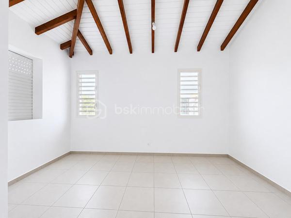 Située à Baie-Mahault, dans un environnement résidentiel au calme, je vous propose cette superbe villa neuve de plain-pied de 105 m² (surface utile 144,65 m2), édifiée sur une parcelle de 586 m² sécurisée par un portail motorisé.
À l’avant de la maison une grande terrasse de 39 m2, attenante à un WC visiteur indépendant.
Un séjour de 32 m2 environ offre une belle pièce de vie, lumineuse ouverte sur la terrasse.
La cuisine aménagée avec une vue sur le jardin, avec un beau cellier pour le rangement de vos provisions.
Concernant la partie nuit, un dégagement dessert une salle d’eau/WC, trois chambres, dont une belle suite parentale de 18,53 m2 avec sa salle d’eau/WC, ainsi qu’une buanderie indépendante.
Vous l’aurez compris, cette maison NEUVE est prête à accueillir votre famille. Elle vous séduira par ses volumes, sa luminosité et son emplacement dans ce secteur apprécié pour :
- son environnement résidentiel calme ;
- sa proximité avec le centre de Baie-Mahault ;
- son accès rapide à Jarry, Destreland, aux écoles et aux principaux axes routiers

Les maisons neuves disponibles immédiatement sont peu nombreuses sur le marché. Si vous recherchez un bien confortable, moderne et prêt à accueillir votre famille, ne tardez pas à programmer votre visite.
📞 Contactez-moi dès aujourd'hui. Une visite pourrait être le début de votre nouveau projet de vie.