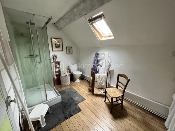 Située en plein cœur historique de La Charité-sur-Loire, dans une rue calme récemment réhabilitée, cette demeure unique de 194m² bouscule les codes de l'immobilier classique. Née de la fusion audacieuse de deux bâtisses anciennes, elle a été en partie repensée par un architecte pour offrir un cadre de vie singulier, lumineux et résolument atypique. Son emplacement est idéal, puisque vous rejoignez les bords de la Loire, les commerces du centre-ville et la gare en moins de dix minutes à pied, plaçant Paris à seulement deux heures de votre porte.

Dès l'entrée, le charme opère grâce aux carreaux de ciment d’époque qui mènent à un premier espace de vie de 34m² avec cuisine ouverte. Cet espace se prolonge naturellement vers un jardinet intimiste orienté plein Ouest et totalement préservé des regards. Le véritable coup de génie architectural réside dans une superbe verrière chauffée qui sert de trait d'union entre les deux corps de bâtiment. Elle mène à un second salon-séjour de 33m², véritable pièce maîtresse avec ses murs en pierres apparentes, ses poutres massives, son sol en travertin et sa grande cheminée d'époque. Ce niveau comprend également une chambre confortable de 14m², un atelier-buanderie fonctionnel, une salle d'eau avec WC et l'accès à une magnifique double cave voûtée.

À l'étage, accessible par un bel escalier en pierre de taille, l'atmosphère devient encore plus chaleureuse avec des parquets en chêne massif d'origine. Un vaste palier de 11m², idéal pour aménager un bureau, distribue les espaces de nuit. Vous y découvrirez une suite magistrale de 38m² au cachet exceptionnel, ainsi qu'une troisième chambre de 18m² surplombée par une grande mezzanine de 21m² au sol, parfaite pour un espace de jeu, de lecture ou un coin dortoir. Une grande salle d'eau indépendante de 9m² complète ce niveau.

Entièrement rénovée avec des matériaux de grande qualité, cette maison bénéficie d'une excellente technique avec des huisseries en bois double vitrage, une façade fraîchement ravalée, une toiture en ardoise en très bon état et un chauffage central au gaz de ville performant et récent. Que ce soit pour y installer une vie de famille ou pour en faire une résidence secondaire chaleureuse et sans aucun travaux à prévoir, cette propriété rare n'attend plus que vos projets. Une visite vidéo est disponible sur simple demande pour vous imprégner de l'atmosphère des lieux.

Photos supplémentaires disponibles sur BSK IMMOBILIER > Nos conseillers > Inès RÉMOND
Pour tout renseignement complémentaire ou pour une visite, contactez moi au 07.87.29.70.92.
