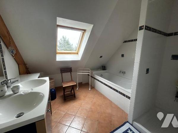 Une maison contemporaine, séjour/salon, cuisine aménagée, quatre chambres, véranda, sous-sol.