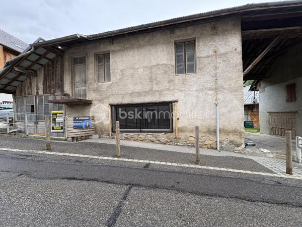 Un lieu chargé d’histoire, au centre d’un village de montagne authentique, offrant un potentiel rare.
Cette bâtisse en pierre, autrefois la forge du village, se situe au cœur de La Compôte, dans le massif préservé des Bauges. Elle bénéficie d’un environnement naturel exceptionnel : départs de randonnées, lacs, stations et paysages alpins accessibles en quelques minutes.

Un permis existant et un potentiel d’évolution remarquable
Le permis de construire actuellement validé prévoit deux plateaux pour une surface totale d’environ 135 m² aménageables.
Ce cadre offre déjà une base solide pour un projet d’habitation ou d’investissement.
Mais l’intérêt majeur réside dans la possibilité de modifier ce permis, ouvrant la voie à des aménagements plus ambitieux, jusqu’à environ 160 m² habitables selon les configurations.

Plusieurs scénarios deviennent alors envisageables:
Un grand logement familial de type T5
Deux logements distincts (T3 + T5)
Un projet modulé selon vos besoins, vos envies ou votre stratégie patrimoniale
La hauteur sous plafond et la charpente apparente permettent d’imaginer des volumes lumineux, uniques, avec un cachet exceptionnel.

 Caractéristiques et atouts:
Bâtisse en pierre, saine et rassurante
Raccordement électrique réalisé
Toiture partiellement refaite en bac acier (reste en tôle en bon état)
Possibilité de stationnement privatif couvert
Espaces terrasses exploitables
Volume intéressant pour entreposer du matériel ou créer un espace de travail selon projet
Idéal pour un investissement locatif, un projet familial ou un lieu de vie atypique

 Travaux à prévoir:
*Raccordement au tout-à-l’égout
*Raccordement à l’eau
*Aménagement intérieur complet selon le projet retenu

Un lieu à ressentir
Cette ancienne forge est un lieu qui se visite pour en saisir l’âme et le potentiel.
Même sans terrain, la nature environnante devient votre véritable espace extérieur : forêts, montagnes, sentiers, activités de plein air… Un cadre de vie rare.
La lumière, les volumes et la charpente confèrent à cette bâtisse un charme unique, difficile à percevoir sans s’y rendre.
Pour vous aider à vous projeter, un travail d’esquisse et de réflexion a été mené avec Chlôme (architecte / maître d’œuvre). Cette approche, indépendante du permis de construire existant, ouvre des perspectives intéressantes pour un futur projet.

Je reste à votre écoute pour toute question et, si cette bâtisse éveille votre intérêt, je suis disponible pour vous la faire visiter.