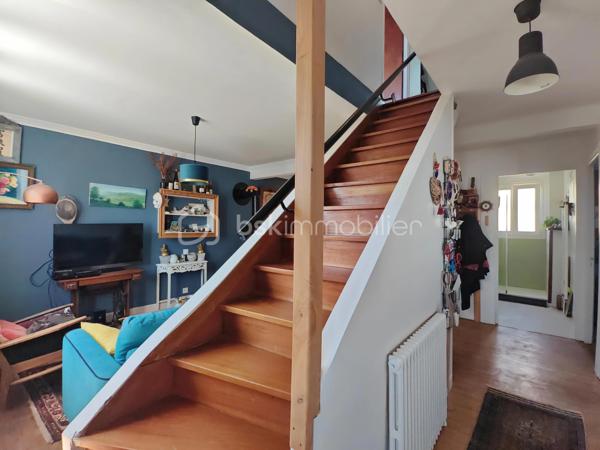 Construite vers 1950 et entièrement rénovée avec personnalité, cette maison bretonne singulière se déploie sur 3 niveaux (avec possibilité d'aménager un 4ᵉ niveau) dans un style éclectique affirmé. Une demeure pleine d'âme, prête à accueillir ses futurs propriétaires.
Surfaces : 111 m² habitables, complétés par environ 80 m² au rez-de-jardin.
Emplacement idéal : à quelques pas du centre-ville, des écoles, des commerces et des transports, la maison conjugue praticité et environnement paisible.

3 min de la quatre-voies
5 min de la gare
15 min de Lorient

Rez-de-jardin : garage, buanderie et atelier occupant toute l'emprise du bâtiment — un fort potentiel d'aménagement. Le grand jardin, planté d'un cognassier, accueille également un cabanon pouvant abriter lapins ou poules.
1er étage : belle entrée centrale, lumineuse et chaleureuse, distribuant l'ensemble des pièces. Elle ouvre sur une cuisine, une chambre, une salle d'eau moderne (douche à l'italienne et WC) ainsi qu'un double séjour donnant directement sur une terrasse sur pilotis plein sud, qui mène au jardin. Luminosité exceptionnelle et vue perchée particulièrement apaisante.
2ᵉ étage : vaste chambre avec coin bureau, superbe salle de bains (double vasque, baignoire en fonte, WC, verrière), dressing pouvant être transformé en chambre indépendante, ainsi qu'une 3ᵉ chambre.
Grenier : 80 m² au sol, aménageable en pièce de vie supplémentaire avec possibilité d'installation de Velux (sous réserve d'accord), ou à transformer en volume cathédrale sous charpente apparente.
Prestations techniques : chauffage au gaz (chaudière récente), poêle à bois, plomberie refaite à neuf.

En résumé : une maison à l'âme bobo assumée, sans compromis et sans travaux à prévoir, à proximité immédiate du centre-ville. Posez simplement vos valises !