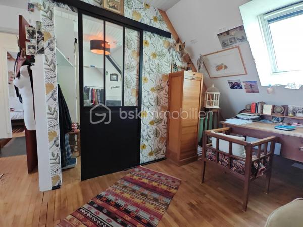 Construite vers 1950 et entièrement rénovée avec personnalité, cette maison bretonne singulière se déploie sur 3 niveaux (avec possibilité d'aménager un 4ᵉ niveau) dans un style éclectique affirmé. Une demeure pleine d'âme, prête à accueillir ses futurs propriétaires.
Surfaces : 111 m² habitables, complétés par environ 80 m² au rez-de-jardin.
Emplacement idéal : à quelques pas du centre-ville, des écoles, des commerces et des transports, la maison conjugue praticité et environnement paisible.

3 min de la quatre-voies
5 min de la gare
15 min de Lorient

Rez-de-jardin : garage, buanderie et atelier occupant toute l'emprise du bâtiment — un fort potentiel d'aménagement. Le grand jardin, planté d'un cognassier, accueille également un cabanon pouvant abriter lapins ou poules.
1er étage : belle entrée centrale, lumineuse et chaleureuse, distribuant l'ensemble des pièces. Elle ouvre sur une cuisine, une chambre, une salle d'eau moderne (douche à l'italienne et WC) ainsi qu'un double séjour donnant directement sur une terrasse sur pilotis plein sud, qui mène au jardin. Luminosité exceptionnelle et vue perchée particulièrement apaisante.
2ᵉ étage : vaste chambre avec coin bureau, superbe salle de bains (double vasque, baignoire en fonte, WC, verrière), dressing pouvant être transformé en chambre indépendante, ainsi qu'une 3ᵉ chambre.
Grenier : 80 m² au sol, aménageable en pièce de vie supplémentaire avec possibilité d'installation de Velux (sous réserve d'accord), ou à transformer en volume cathédrale sous charpente apparente.
Prestations techniques : chauffage au gaz (chaudière récente), poêle à bois, plomberie refaite à neuf.

En résumé : une maison à l'âme bobo assumée, sans compromis et sans travaux à prévoir, à proximité immédiate du centre-ville. Posez simplement vos valises !