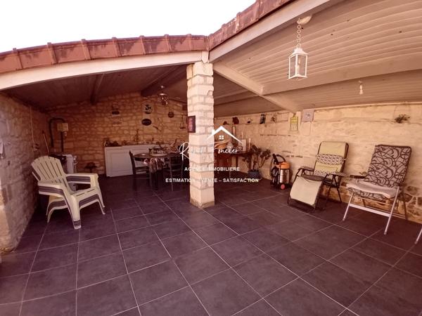 Vue sur le terrain, avec la terrasse et un préau très agréable