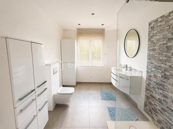 Rebecca Sebarg, BSK Immobilier, a le plaisir de vous présenter cette magnifique maison de plain-pied construite en 1990, implantée sur un terrain d’environ 670 m², dans une impasse au calme, tout en étant à proximité immédiate des commerces.

Dès l’entrée, vous découvrirez un hall accueillant avec un WC indépendant équipé d’un lave-mains.

Vous serez séduits par une spacieuse pièce de vie d’environ 35 m², baignée de lumière, CLIMATISATION, comprenant un double séjour agrémenté d’une cheminée moderne et récente, avec un accès direct à la terrasse et au jardin.

La cuisine ouverte, moderne, entièrement aménagée et équipée, communique directement avec le garage pour un confort de vie optimal.

Un couloir dessert la partie nuit comprenant :
un placard de rangement, 2 chambres, dont une équipée de la CLIMATISATION, une grande salle de bains moderne d’environ 10 m², avec douche à l’italienne, double vasque et WC suspendu.

Un garage d’environ 17 m² ainsi qu’une buanderie viennent compléter ce bien.

Les atouts de cette maison :

- Possibilité de faire le tour de la maison des 2 côtés.
- CLIMATISATION dans le séjour ainsi que dans une chambre.
- Cheminée moderne et récente dans le double séjour.
- Chaudière gaz récente.
- Fenêtres en aluminium double vitrage avec volets roulants électriques.
- Deux stores bannes électriques avec éclairage LED, parfaits pour profiter pleinement de la terrasse.
- Garage d’environ 17 m², entièrement isolé, avec accès aux combles offrant une possibilité d’aménagement.
- Accès direct depuis la buanderie vers l’extérieur et la terrasse, agrémentée d’un joli préau.
- AUCUN VIS-À-VIS!!

Une maison parfaitement entretenue, offrant de belles prestations et un cadre de vie privilégié. Elle séduira les acquéreurs à la recherche d’un environnement paisible, tout en restant proche des commodités.

Une visite s’impose ! Contactez-moi dès maintenant pour découvrir cette belle opportunité.

Taxe foncière: 1870€