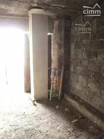 Garage pour motos avec porte en bois à deux vantaux, situé dans une cour.