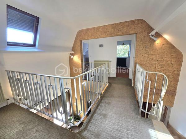 Dans un environnement calme et verdoyant, au fond d’une impasse, cette agréable maison familiale de type T8 développe environ 168 m² habitables et bénéficie de beaux volumes ainsi que d’une excellente luminosité.

Dès l’entrée, vous serez séduit par son plafond cathédrale qui apporte volume et caractère à la pièce. Le rez-de-chaussée se compose d’une entrée, d’une cuisine indépendante donnant sur la terrasse, ainsi que d’un vaste salon-séjour traversant et lumineux, bénéficiant d’une triple exposition et agrémenté d’une cheminée à foyer ouvert. Une terrasse bien exposée, équipée d’un store banne électrique, prolonge agréablement les espaces de vie et permet de profiter pleinement du jardin.
Toujours au rez-de-chaussée, un couloir dessert une buanderie avec placard pouvant également être aménagée en bureau, un WC indépendant, une salle d’eau avec placard ainsi qu’une grande chambre, offrant ainsi une vie de plain-pied particulièrement appréciable.

À l’étage, un palier dessert quatre grandes chambres dont 2 avec des placards, une seconde salle d’eau, un WC indépendant ainsi qu’un débarras.

La maison dispose par ailleurs d’un vaste sous-sol, d’une cave, d’un bûcher et d’un appentis, offrant de nombreuses possibilités de rangement et de stockage.
L’ensemble est implanté sur un terrain de 845 m², dans un cadre verdoyant et résidentiel.

LES ATOUTS
•	Maison familiale de 168 m²
•	5 chambres, dont une au rez-de-chaussée
•	Terrain de 845 m²
•	Environnement calme, au fond d’une impasse
•	Triple exposition du séjour
•	Terrasse bien exposée avec store banne électrique
•	Plafond cathédrale
•	Cheminée à foyer ouvert
•	PAC air/air
•	Chaudière à condensation récente
•	Peintures de l’étage entièrement refaites
•	Toiture nettoyée
•	Maison parfaitement entretenue
•	Matériaux de qualité et nombreux éléments de charme
•	Vaste sous-sol et plusieurs annexes

La maison est parfaitement entretenue et ne nécessite pas de travaux importants.
Quelques rafraîchissements sont toutefois à prévoir dans la cuisine et les deux salles d’eau afin de moderniser ces espaces et de révéler tout le potentiel de cette belle maison familiale.

À découvrir sans tarder.