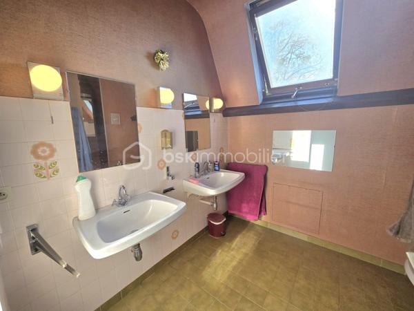 Dans un environnement calme et verdoyant, au fond d’une impasse, cette agréable maison familiale de type T8 développe environ 168 m² habitables et bénéficie de beaux volumes ainsi que d’une excellente luminosité.

Dès l’entrée, vous serez séduit par son plafond cathédrale qui apporte volume et caractère à la pièce. Le rez-de-chaussée se compose d’une entrée, d’une cuisine indépendante donnant sur la terrasse, ainsi que d’un vaste salon-séjour traversant et lumineux, bénéficiant d’une triple exposition et agrémenté d’une cheminée à foyer ouvert. Une terrasse bien exposée, équipée d’un store banne électrique, prolonge agréablement les espaces de vie et permet de profiter pleinement du jardin.
Toujours au rez-de-chaussée, un couloir dessert une buanderie avec placard pouvant également être aménagée en bureau, un WC indépendant, une salle d’eau avec placard ainsi qu’une grande chambre, offrant ainsi une vie de plain-pied particulièrement appréciable.

À l’étage, un palier dessert quatre grandes chambres dont 2 avec des placards, une seconde salle d’eau, un WC indépendant ainsi qu’un débarras.

La maison dispose par ailleurs d’un vaste sous-sol, d’une cave, d’un bûcher et d’un appentis, offrant de nombreuses possibilités de rangement et de stockage.
L’ensemble est implanté sur un terrain de 845 m², dans un cadre verdoyant et résidentiel.

LES ATOUTS
•	Maison familiale de 168 m²
•	5 chambres, dont une au rez-de-chaussée
•	Terrain de 845 m²
•	Environnement calme, au fond d’une impasse
•	Triple exposition du séjour
•	Terrasse bien exposée avec store banne électrique
•	Plafond cathédrale
•	Cheminée à foyer ouvert
•	PAC air/air
•	Chaudière à condensation récente
•	Peintures de l’étage entièrement refaites
•	Toiture nettoyée
•	Maison parfaitement entretenue
•	Matériaux de qualité et nombreux éléments de charme
•	Vaste sous-sol et plusieurs annexes

La maison est parfaitement entretenue et ne nécessite pas de travaux importants.
Quelques rafraîchissements sont toutefois à prévoir dans la cuisine et les deux salles d’eau afin de moderniser ces espaces et de révéler tout le potentiel de cette belle maison familiale.

À découvrir sans tarder.