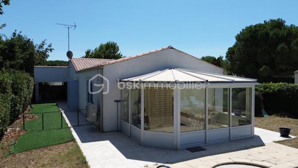 À La Tremblade, cette maison de plain-pied de 134 m² offre des volumes généreux et une organisation particulièrement agréable au quotidien.

Son principal atout est son vaste espace de vie. La pièce de vie traversante avec plafond cathédrale, la cuisine ouverte et la véranda forment un ensemble d’environ 70 m². La véranda prolonge naturellement le séjour vers le jardin et la piscine et permet de profiter pleinement des extérieurs.

La partie nuit est bien séparée des espaces de vie et comprend trois chambres avec placards ainsi qu’une salle d’eau équipée d’une grande douche et d’un meuble double vasque. Une entrée, un WC indépendant et un cellier/buanderie complètent l’aménagement intérieur.

Construite en 2004, la maison bénéficie également d’une climatisation réversible dans la pièce de vie et la véranda, de nombreux rangements et d’un garage d’environ 25 m².

À l’extérieur, le terrain clos et arboré d’environ 600 m² accueille une piscine, ainsi qu’un grand cabanon et un auvent offrant des espaces supplémentaires de rangement et d’usage.

La maison bénéficie par ailleurs d’une performance énergétique intéressante avec un DPE classé C et un GES classé B.

Marché, commerces, services, écoles et collège sont accessibles sur La Tremblade, avec également à proximité le port de plaisance, la forêt de la Coubre et les plages de la Côte Sauvage.