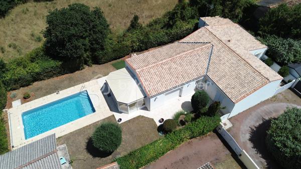 À La Tremblade, cette maison de plain-pied de 134 m² offre des volumes généreux et une organisation particulièrement agréable au quotidien.

Son principal atout est son vaste espace de vie. La pièce de vie traversante avec plafond cathédrale, la cuisine ouverte et la véranda forment un ensemble d’environ 70 m². La véranda prolonge naturellement le séjour vers le jardin et la piscine et permet de profiter pleinement des extérieurs.

La partie nuit est bien séparée des espaces de vie et comprend trois chambres avec placards ainsi qu’une salle d’eau équipée d’une grande douche et d’un meuble double vasque. Une entrée, un WC indépendant et un cellier/buanderie complètent l’aménagement intérieur.

Construite en 2004, la maison bénéficie également d’une climatisation réversible dans la pièce de vie et la véranda, de nombreux rangements et d’un garage d’environ 25 m².

À l’extérieur, le terrain clos et arboré d’environ 600 m² accueille une piscine, ainsi qu’un grand cabanon et un auvent offrant des espaces supplémentaires de rangement et d’usage.

La maison bénéficie par ailleurs d’une performance énergétique intéressante avec un DPE classé C et un GES classé B.

Marché, commerces, services, écoles et collège sont accessibles sur La Tremblade, avec également à proximité le port de plaisance, la forêt de la Coubre et les plages de la Côte Sauvage.