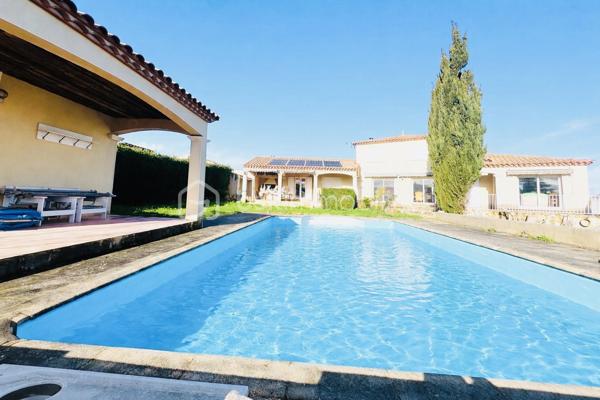 OUVEILLAN – Élégante villa avec piscine et art de vivre méditerranéen – 170 m² – Parcelle de 1 605 m² – 4 CHAMBRES (ou 3 plus BUREAU)

À quelques minutes de Narbonne et des plages, dans un environnement résidentiel calme et recherché, cette propriété dévoile un cadre de vie privilégié où confort et douceur de vivre se conjuguent parfaitement.

Dès les premiers regards, le charme opère : implantée sur une parcelle paysager de 1 605 m², exposée plein sud, la villa s’organise autour d’un espace extérieur remarquable, sublimée par une superbe piscine, véritable cœur de la propriété, idéale pour des moments de détente en toute intimité.

Développant environ 170 m² habitables, la maison offre de beaux volumes baignés de lumière. Le séjour de 55 m², avec cheminée, s’ouvre naturellement sur la terrasse et l’espace piscine, créant une parfaite continuité entre intérieur et extérieur.

La cuisine indépendante, entièrement équipée, s’accompagne d’une arrière-cuisine fonctionnelle. Le rez-de-chaussée accueille également une chambre, un bureau, un dressing ainsi qu’une salle d’eau avec douche à l’italienne et baignoire.

À l’étage, deux chambres supplémentaires, une salle d’eau et un WC indépendant viennent compléter l’ensemble, offrant un espace nuit confortable et bien agencé.

À l’extérieur, tout est pensé pour profiter pleinement du climat méditerranéen : terrasse carrelée avec barbecue, espace détente, sauna et jardin arboré sans vis-à-vis.

Prestations : climatisation réversible, cheminée, menuiseries aluminium double vitrage, volets roulants électriques, garage et stationnements privatifs, portail électrique.

Une propriété aux accents de villégiature, idéale pour une résidence principale ou secondaire, où chaque détail invite à profiter d’un art de vivre ensoleillé.