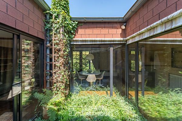 Pépite moderniste de plain-pied et son patio central sous un spectaculaire manteau d’ardoise