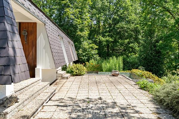Pépite moderniste de plain-pied et son patio central sous un spectaculaire manteau d’ardoise