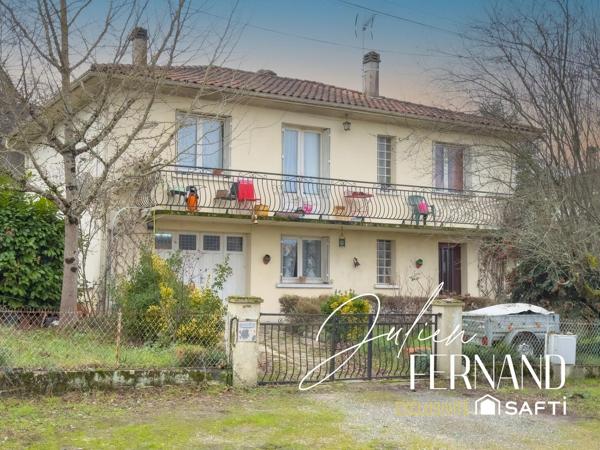Maison à étage avec garage et jardin.