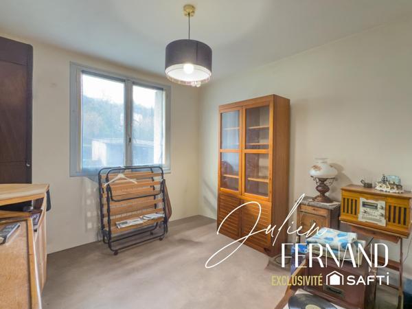 Maison à étage avec garage et jardin.