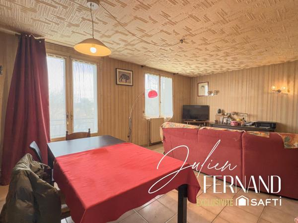 Maison à étage avec garage et jardin.