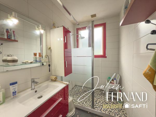 Maison à étage avec garage et jardin.