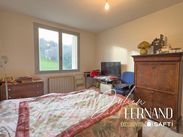 Maison à étage avec garage et jardin.