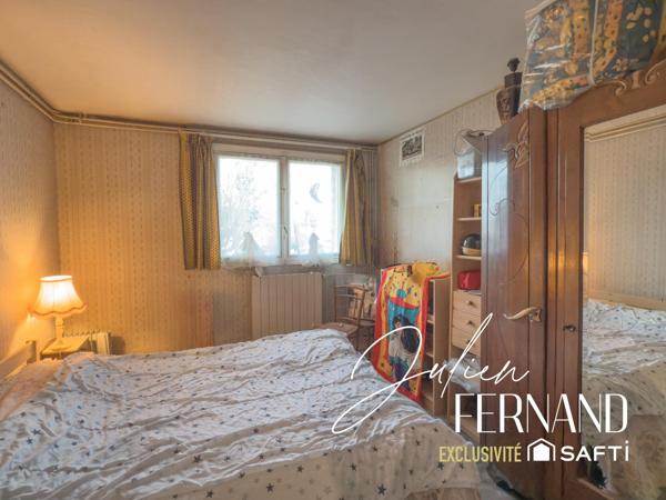 Maison à étage avec garage et jardin.