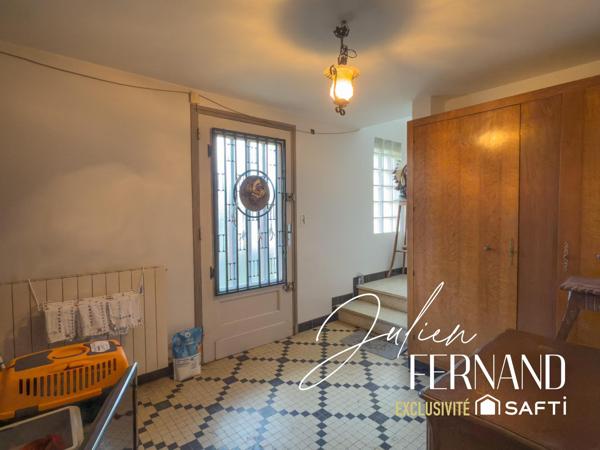 Maison à étage avec garage et jardin.