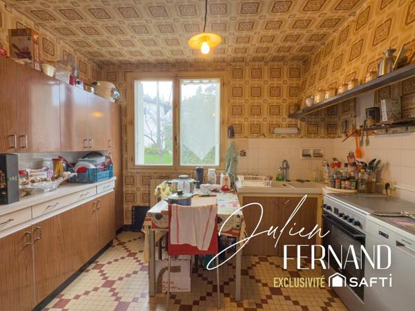 Maison à étage avec garage et jardin.