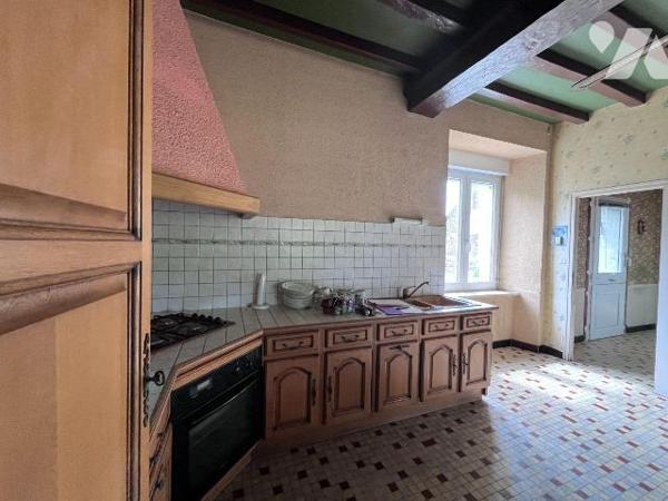 Une maison d habitation en pierres comprenant au rez de chaussée: entrée, cuisine avec cheminée...