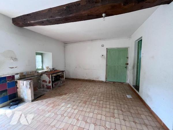 Une maison d habitation en pierres comprenant au rez de chaussée: entrée, cuisine avec cheminée...