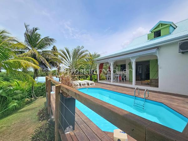 EXCLUSIVITE 
Delphine MIRANDA pour BSK Immobilier 
Jolie nouveauté dans un lotissement résidentiel en haut d'un morne, proche du centre bourg de Sainte Anne et ses commodités, 
Sur une parcelle de 800 m2 entièrement clôturée et végétalisée , vous accédez par le  portail sécurisé à une grande aire de stationnement pouvant abriter à minima 4 véhicules.
Passez le porche d'entrée vous trouverez un grand salon séjour en L ouvert sur la terrasse , une cuisine équipée avec son cellier buanderie attenant avec accès direct sur le jardin. Deux chambres climatisées et une salle d'eau avec douche et toilettes et une grande suite parentale (orientée côté piscine) avec sa salle d'eau / wc viennent compléter ce niveau.
A l'étage en mezzanine se trouve une belle pièce climatisée de 28 m2 aménagée en 4ème chambre avec de nombreux rangements.
Les extérieurs ne sont pas en reste puisque vous disposez d'une terrasse abritée avec son coin repas , un carbet coin détente orienté sur la piscine (filtration au sel)  prolongée par un deck avec vue dégagée assurant une bonne ventilation.
Ses atouts majeurs :
- 4 chambres
- piscine 
- boulodrome 
- citerne tampon 
- chauffe-eau solaire
- jardin entretenu avec fruitiers entièrement clôturé 
La villa d'une surface habitable de 120 m2 (170 m2 de surface utile) est vendue meublée clé en main , idéal pour une résidence principale ou investissement locatif.
Pour plus d'informations , accéder aux vidéos , n'hésitez pas à me contacter au 06 90 90 28 32 , merci de privilégier le premier contact par appel ou message whatsapp.