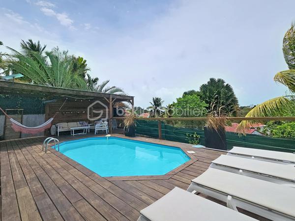 EXCLUSIVITE 
Delphine MIRANDA pour BSK Immobilier 
Jolie nouveauté dans un lotissement résidentiel en haut d'un morne, proche du centre bourg de Sainte Anne et ses commodités, 
Sur une parcelle de 800 m2 entièrement clôturée et végétalisée , vous accédez par le  portail sécurisé à une grande aire de stationnement pouvant abriter à minima 4 véhicules.
Passez le porche d'entrée vous trouverez un grand salon séjour en L ouvert sur la terrasse , une cuisine équipée avec son cellier buanderie attenant avec accès direct sur le jardin. Deux chambres climatisées et une salle d'eau avec douche et toilettes et une grande suite parentale (orientée côté piscine) avec sa salle d'eau / wc viennent compléter ce niveau.
A l'étage en mezzanine se trouve une belle pièce climatisée de 28 m2 aménagée en 4ème chambre avec de nombreux rangements.
Les extérieurs ne sont pas en reste puisque vous disposez d'une terrasse abritée avec son coin repas , un carbet coin détente orienté sur la piscine (filtration au sel)  prolongée par un deck avec vue dégagée assurant une bonne ventilation.
Ses atouts majeurs :
- 4 chambres
- piscine 
- boulodrome 
- citerne tampon 
- chauffe-eau solaire
- jardin entretenu avec fruitiers entièrement clôturé 
La villa d'une surface habitable de 120 m2 (170 m2 de surface utile) est vendue meublée clé en main , idéal pour une résidence principale ou investissement locatif.
Pour plus d'informations , accéder aux vidéos , n'hésitez pas à me contacter au 06 90 90 28 32 , merci de privilégier le premier contact par appel ou message whatsapp.