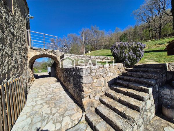Spacieuse bastide en pierres avec dépendances et jardin paysager.