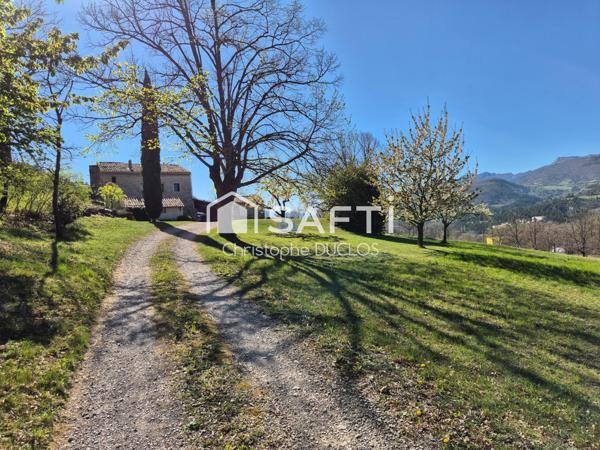 Spacieuse bastide en pierres avec dépendances et jardin paysager.