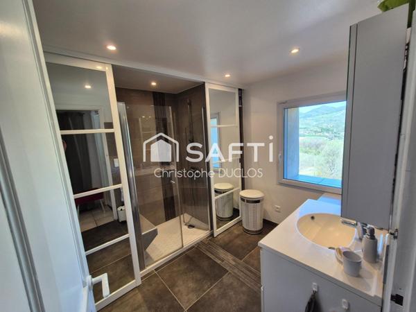 Spacieuse bastide en pierres avec dépendances et jardin paysager.