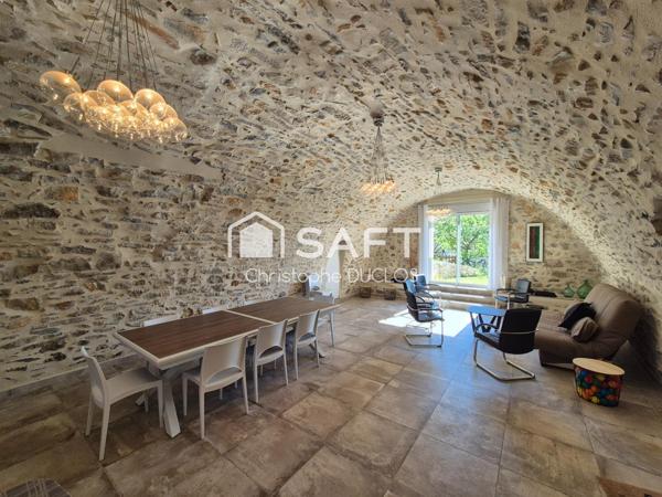 Spacieuse bastide en pierres avec dépendances et jardin paysager.