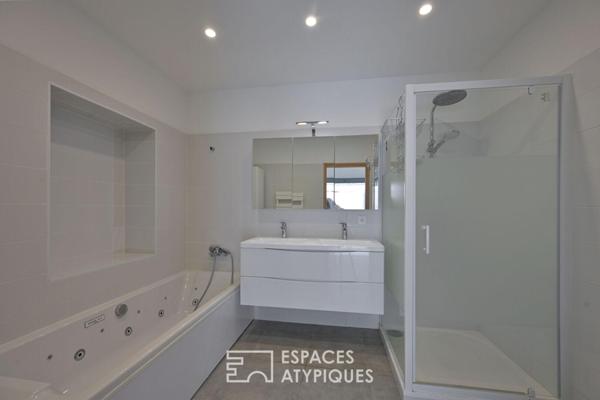 Maison de village à la réhabilitation contemporaine avec cours.